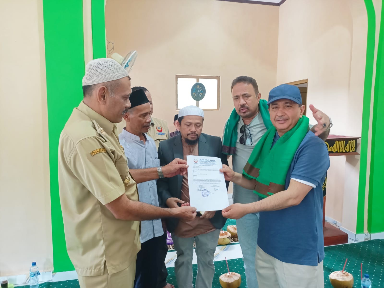 Participants display a document during the mosque handover.