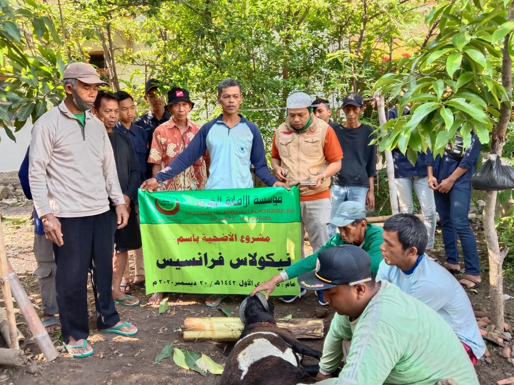 مجموعة رجال يحملون لافتة أمام القائمين على تجهيز الأضحية في حديقة