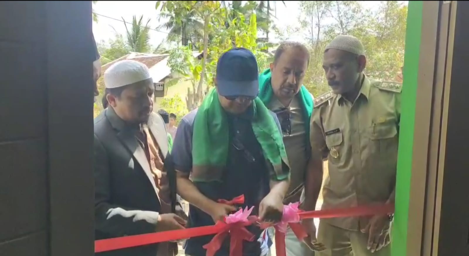 Participants cut the ribbon at the mosque entrance.