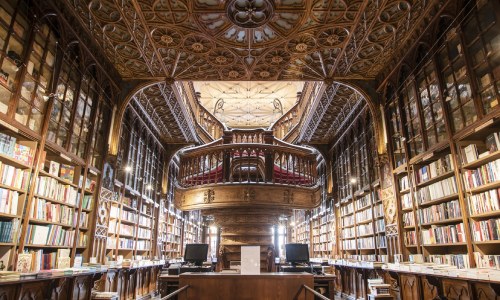 داخل مكتبة كبيرة تضم رفوف كتب وشرفات مزخرفة