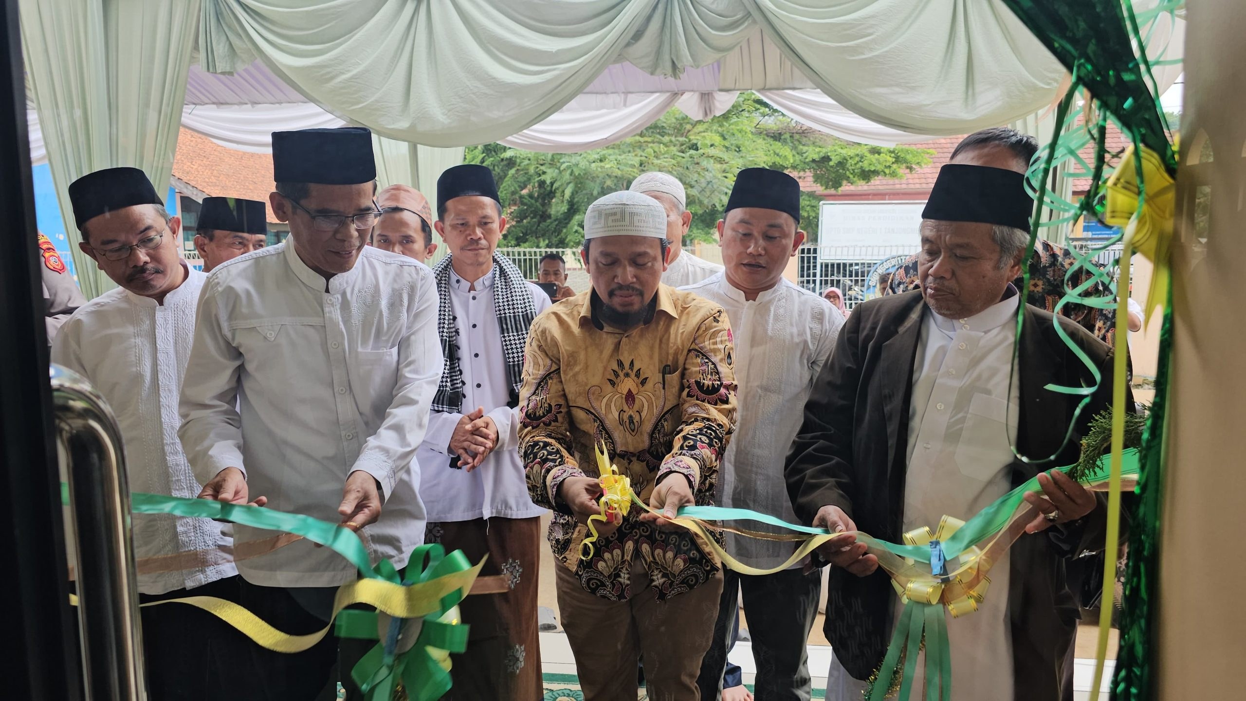 Participants cut the ribbon at the mosque entrance.