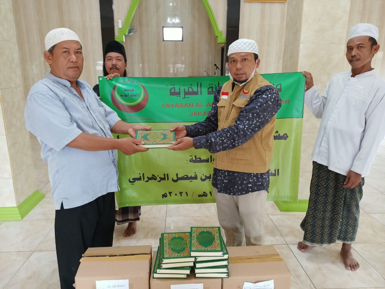 رجلان يحملان لافتة فوق مصاحف وصناديق داخل مسجد