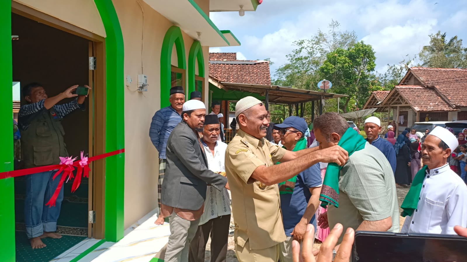 Participants exchange a handshake at the mosque entrance.