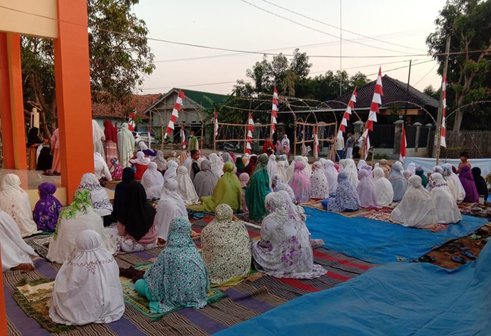 Worshippers sit on mats in the courtyard outside the mosque.