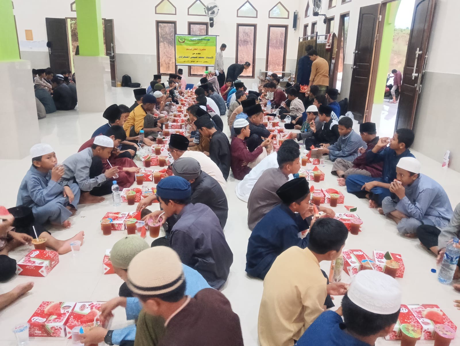 مشاركون يجلسون في صفوف أمام وجبات الإفطار داخل قاعة