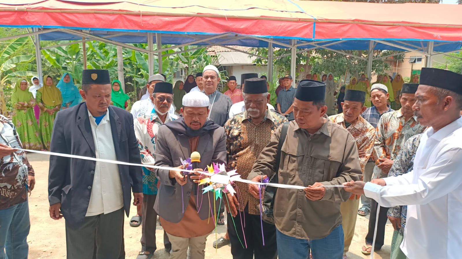 Participants cut the ribbon at the mosque entrance.