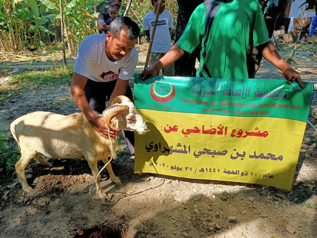 رجلان يعرضان خروفا بجانب لافتة صفراء وخضراء