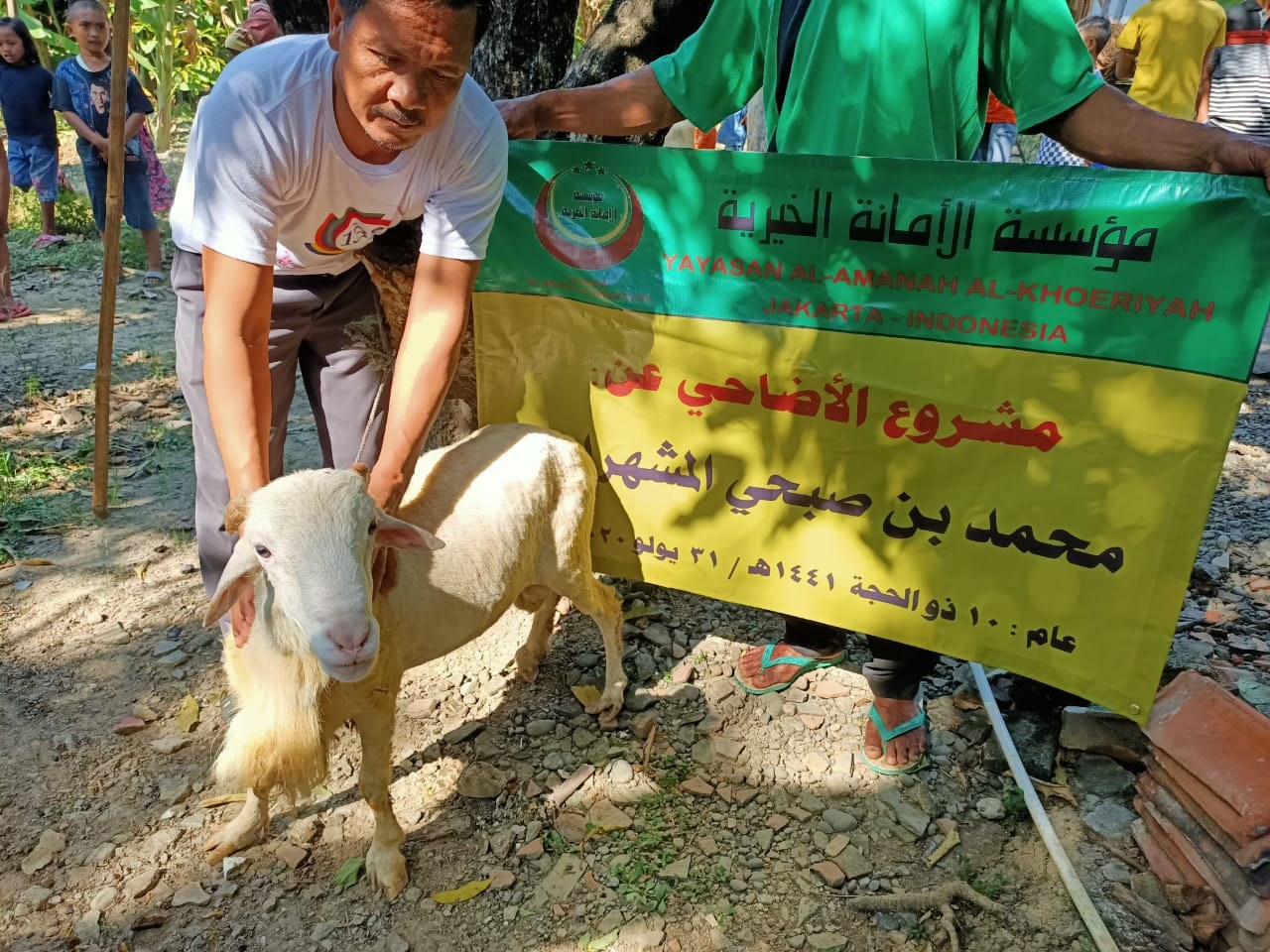 رجل يمسك بخروف أمام لافتة توثيق الأضاحي
