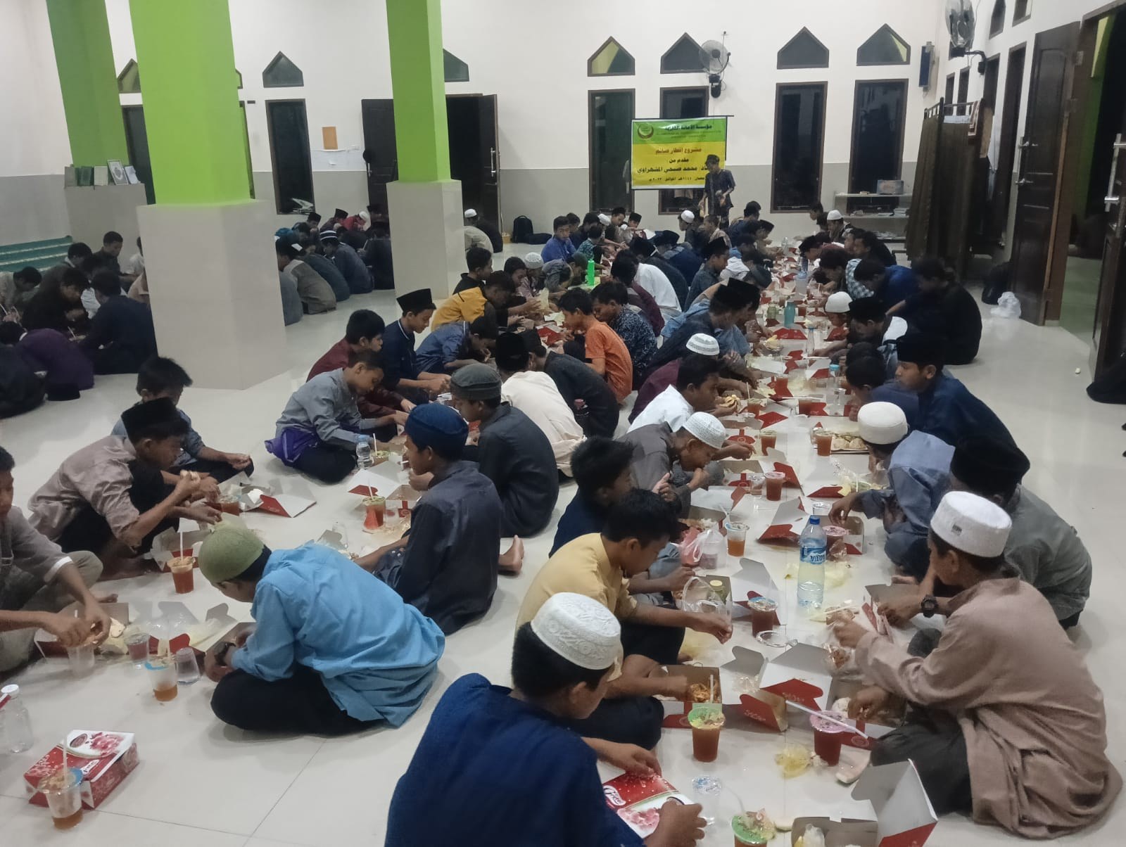 مجموعة تتناول الطعام في وسط القاعة بجوار النوافذ